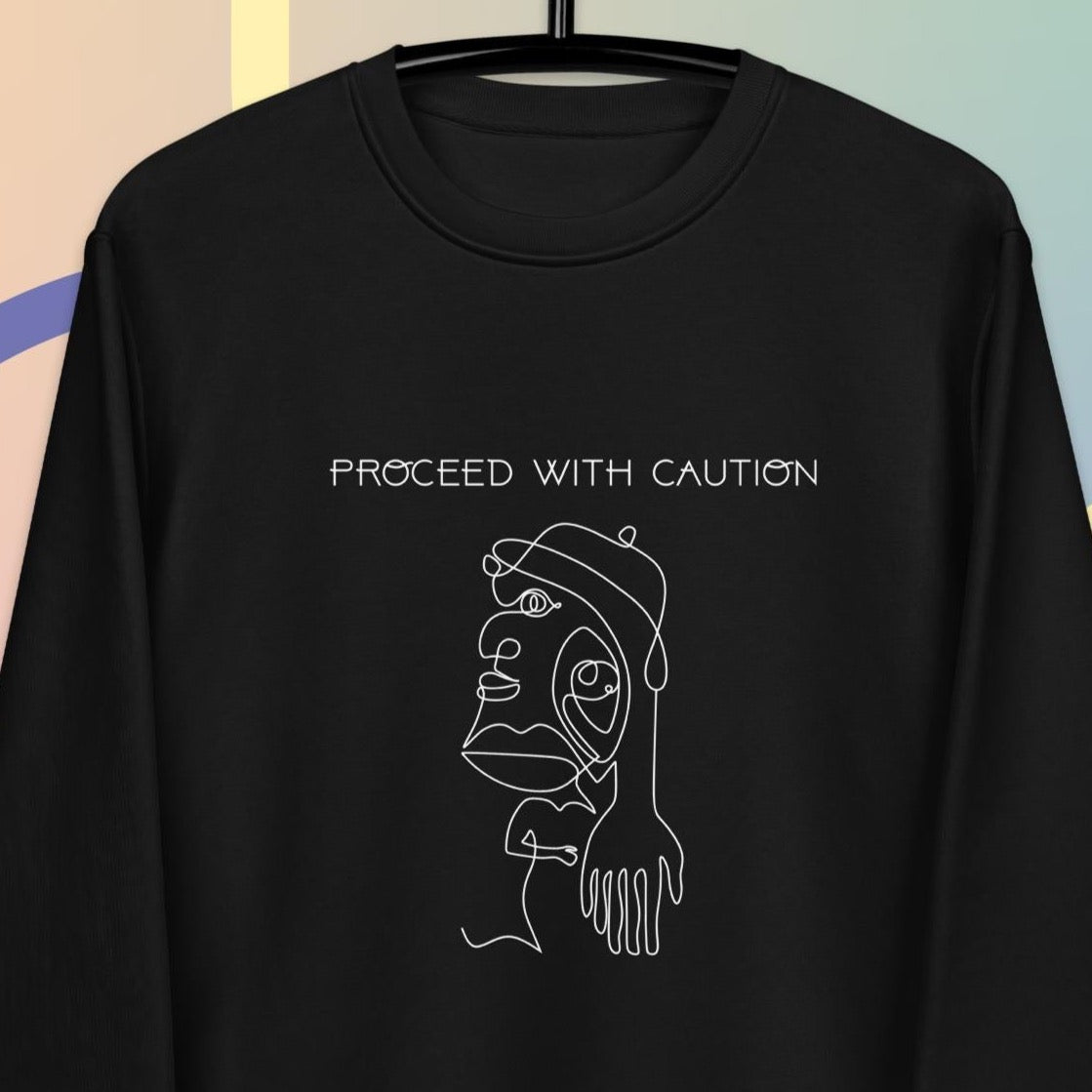 Stay bold in the feminist 'Proceed With Caution' organic cotton sweatshirt—soft, ethical, and powerful.